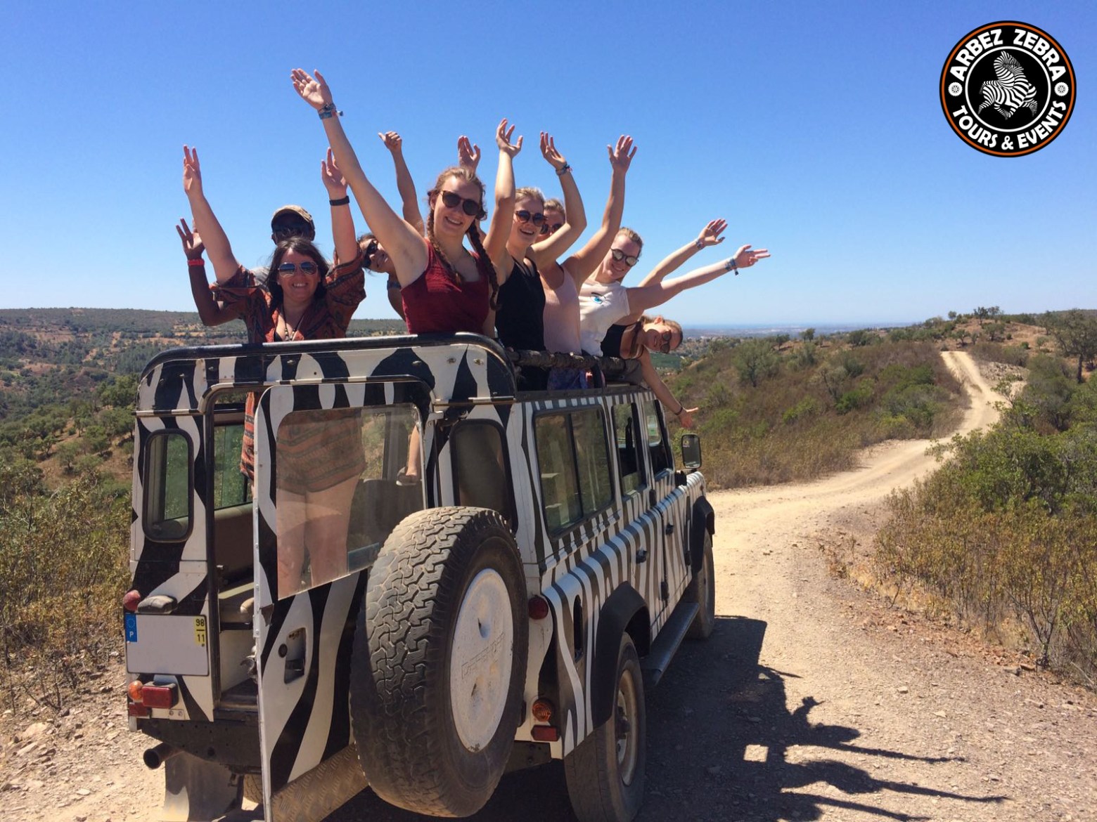 a group of people riding on the back of a jeep