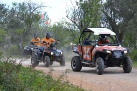 a group of people riding on the back of a buggy and quad bikes