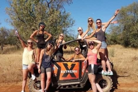 a group of people next to a buggy in a field