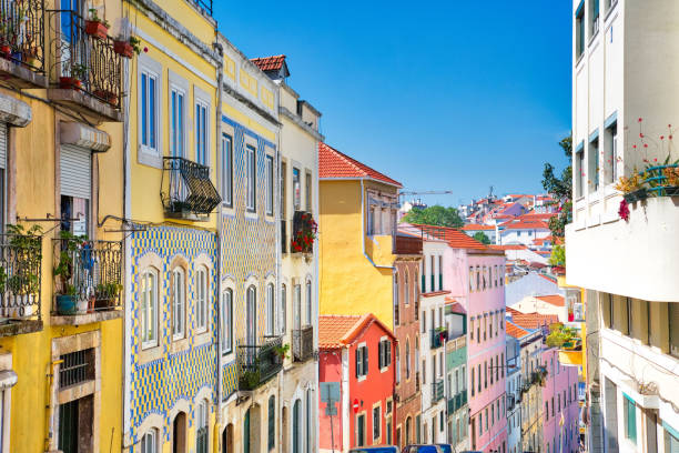 Colorful buildings line a narrow street under a clear blue sky.