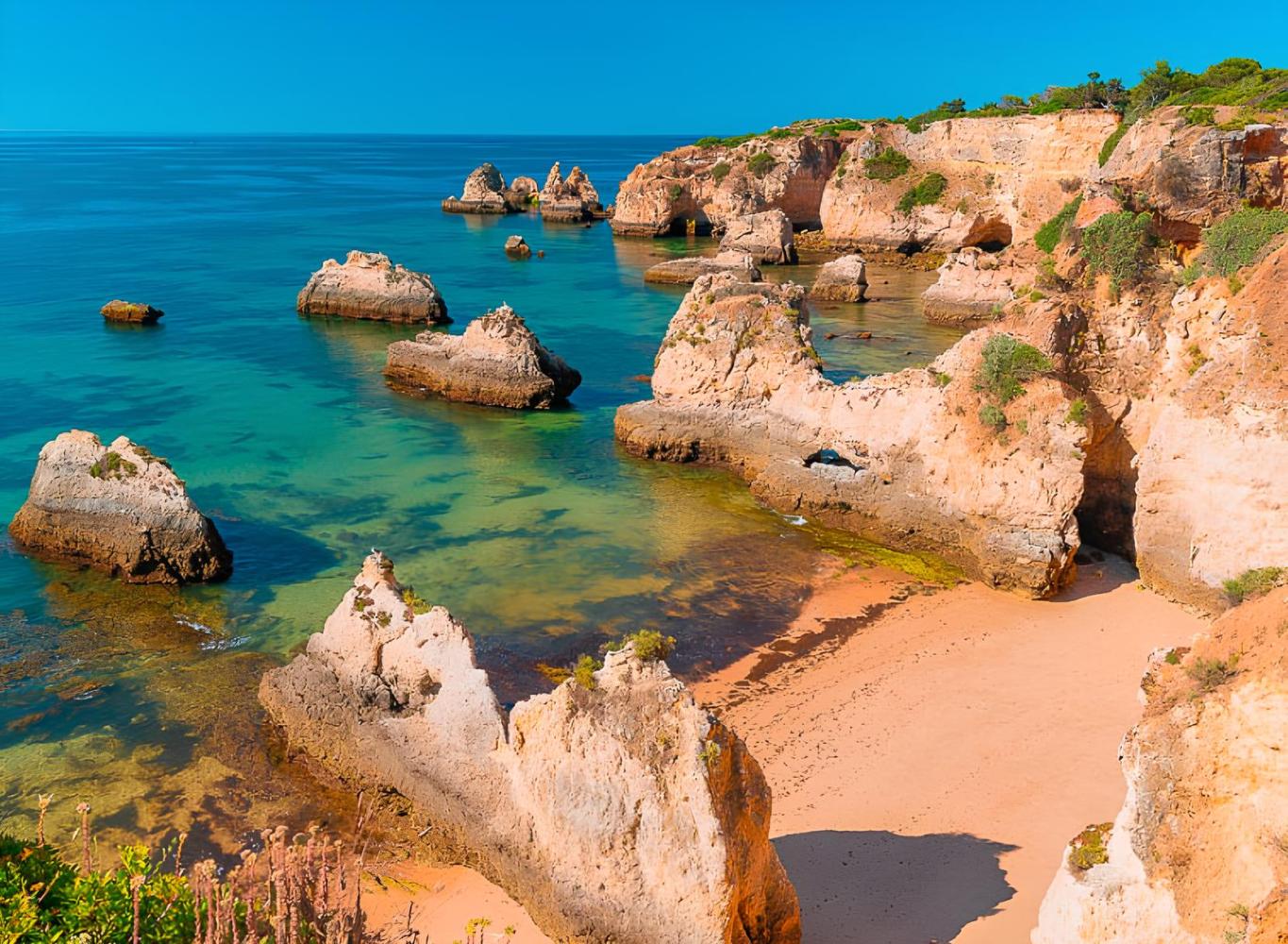Scenic coastal view with rocky cliffs and turquoise water under a clear blue sky.