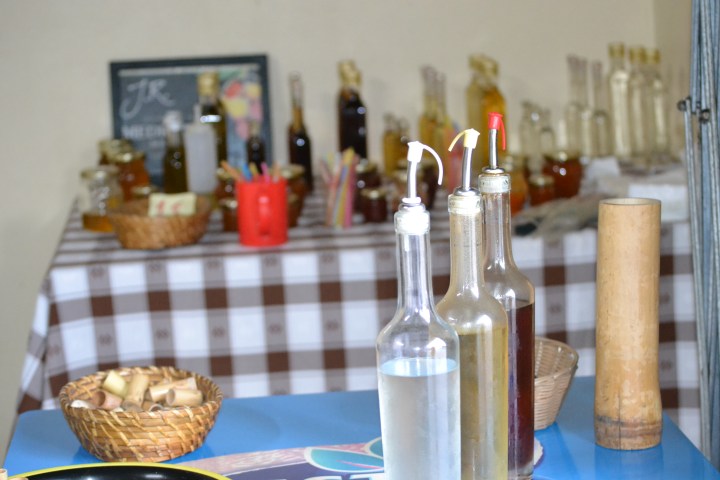 Table with bottles, baskets, and refreshments on a checkered tablecloth.
